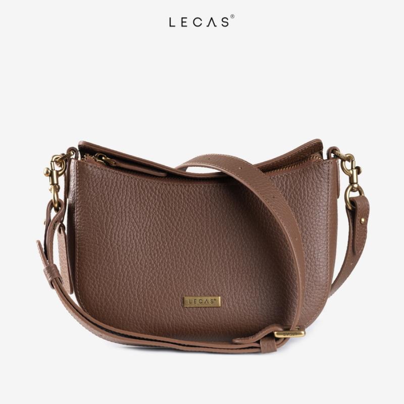 Bàn tay của một người thợ đang kiểm tra đường chỉ may chắc chắn và chất liệu vải dày dặn của một chiếc túi đồ nghề mới, nhấn mạnh tầm quan trọng của việc chọn túi chất lượng.