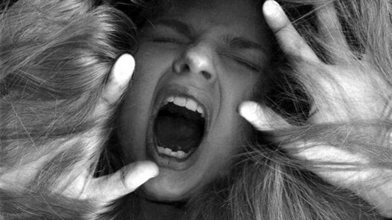 Một người đang ngồi trầm tư viết bài văn tả người thân, xung quanh là sách vở và hình ảnh gia đình, thể hiện sự tập trung và cảm xúc.